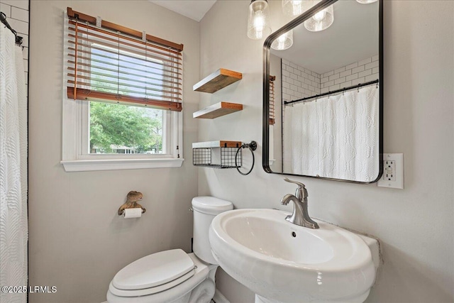 full bath with a sink, toilet, and a shower with curtain