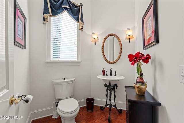 bathroom with wood-type flooring, toilet, and sink