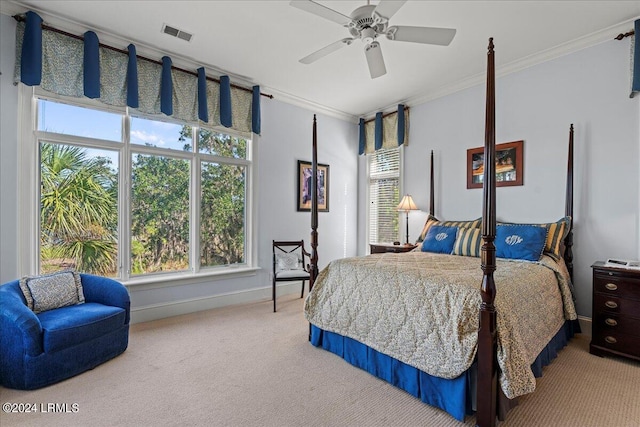 carpeted bedroom with ceiling fan and ornamental molding