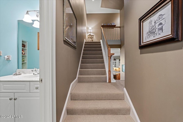 staircase featuring sink and carpet