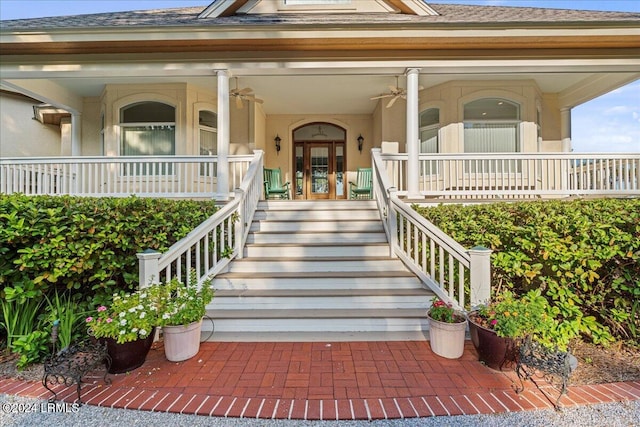 view of exterior entry featuring a porch, ceiling fan, and french doors