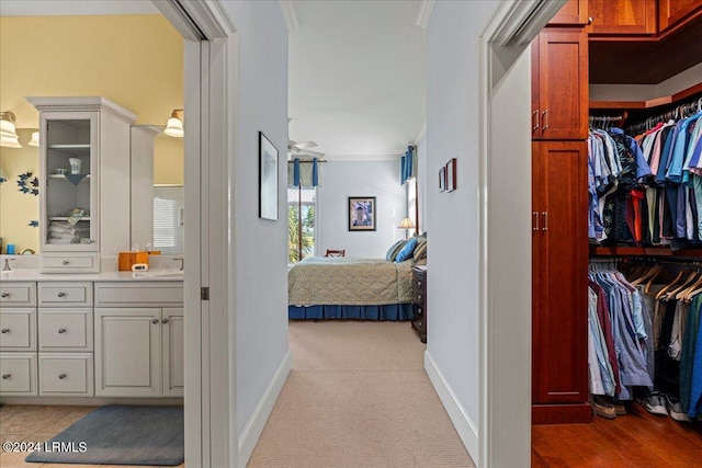 corridor featuring ornamental molding and light carpet