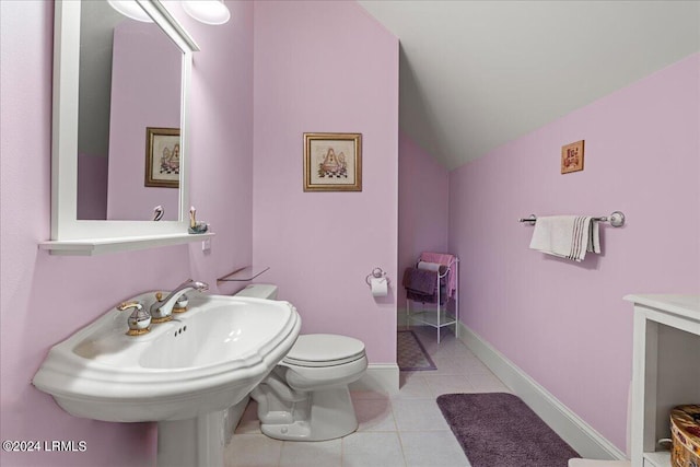 bathroom with lofted ceiling, toilet, tile patterned flooring, and sink