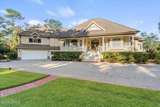 view of front of home with a porch, a garage, and a front lawn