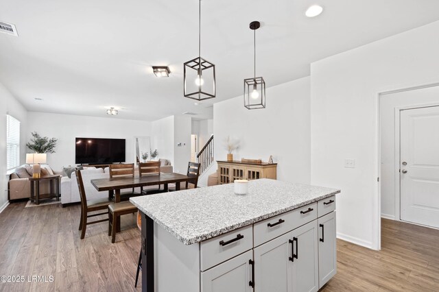68 Keowee Ln, Beaufort, SC 29906 - kitchen with light wood-type flooring, pendant lighting, baseboards, and a kitchen island