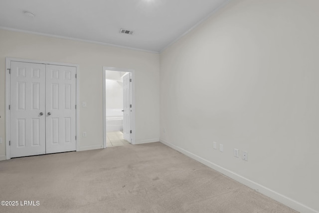 unfurnished bedroom featuring a closet, visible vents, ornamental molding, light carpet, and baseboards