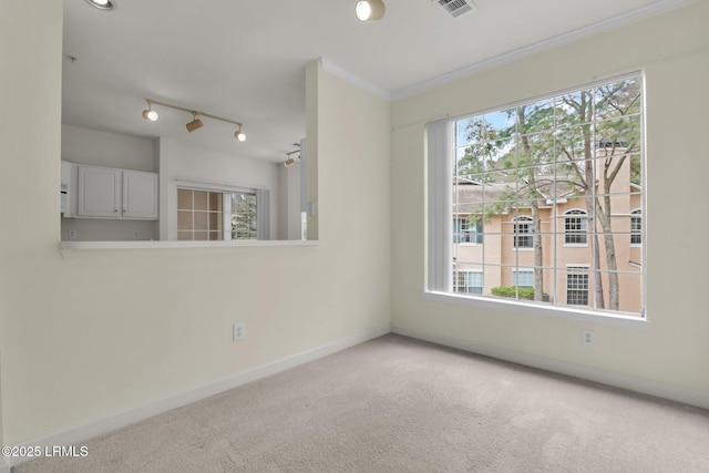 spare room featuring ornamental molding, light carpet, visible vents, and baseboards