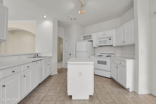 kitchen featuring light countertops, white appliances, a kitchen island, and white cabinets