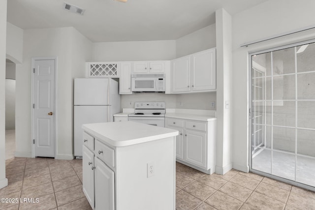 kitchen featuring light countertops, white appliances, a kitchen island, and white cabinetry