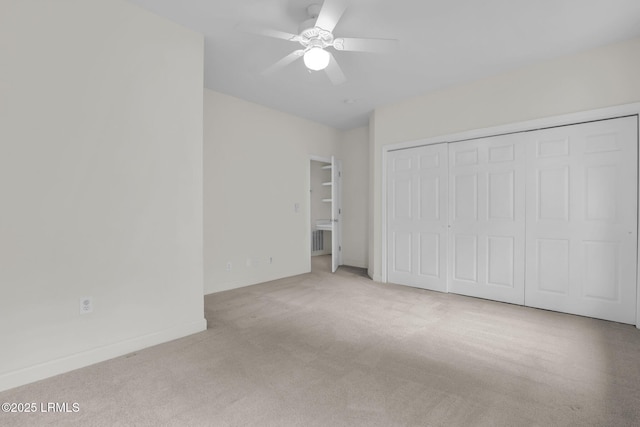 unfurnished bedroom with a ceiling fan, a closet, light colored carpet, and baseboards