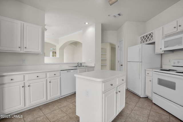 kitchen featuring white cabinets, white appliances, a kitchen island, and light countertops