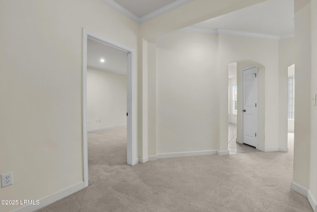 interior space featuring light carpet, baseboards, arched walkways, and crown molding