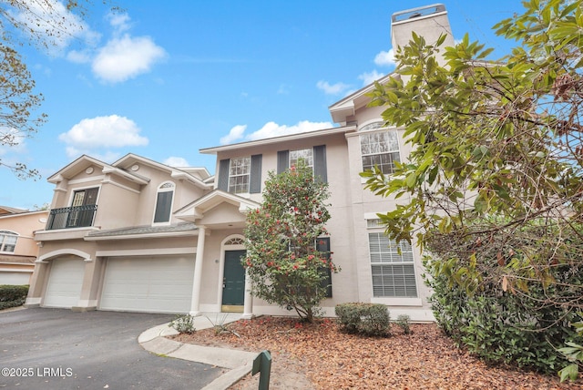 view of front of house with a garage, aphalt driveway, and stucco siding