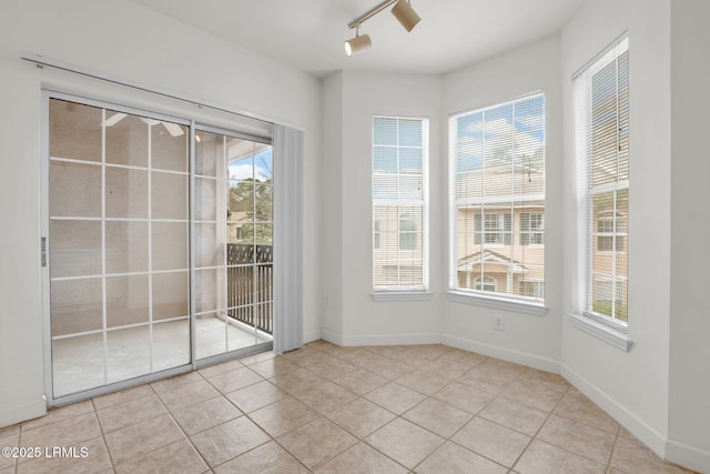 interior space featuring light tile patterned floors, plenty of natural light, and baseboards