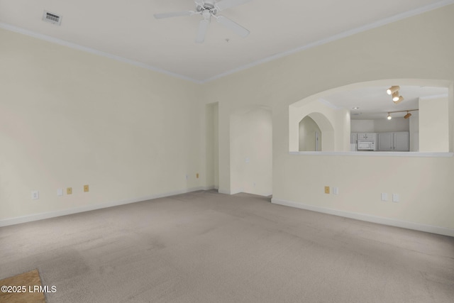 spare room with visible vents, baseboards, ceiling fan, ornamental molding, and carpet floors