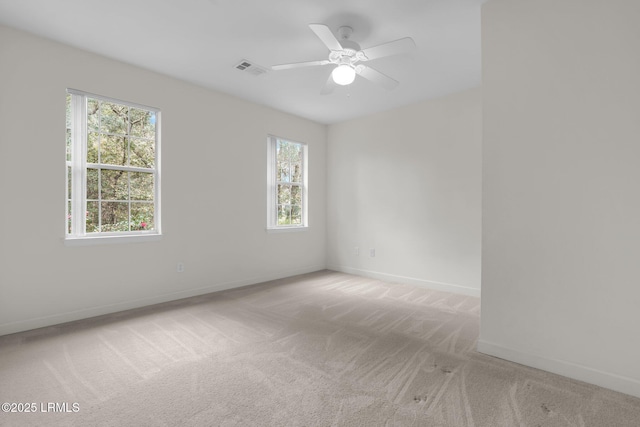 empty room featuring visible vents, baseboards, ceiling fan, and light colored carpet