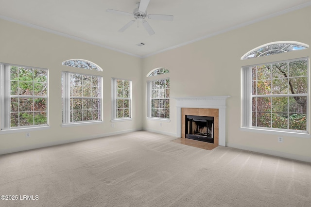 unfurnished living room featuring light carpet, ornamental molding, a tile fireplace, and baseboards