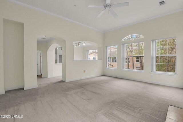 spare room featuring light carpet, ornamental molding, visible vents, and baseboards