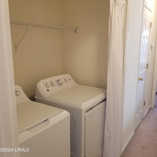 laundry area with separate washer and dryer and light carpet