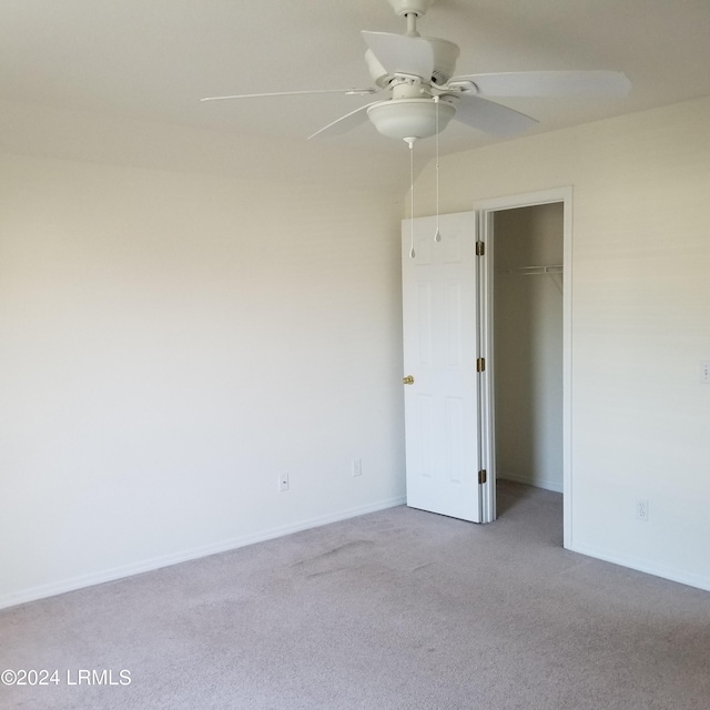 unfurnished bedroom featuring light carpet, ceiling fan, and a closet