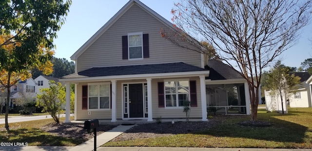 view of front of property featuring a front yard and a sunroom