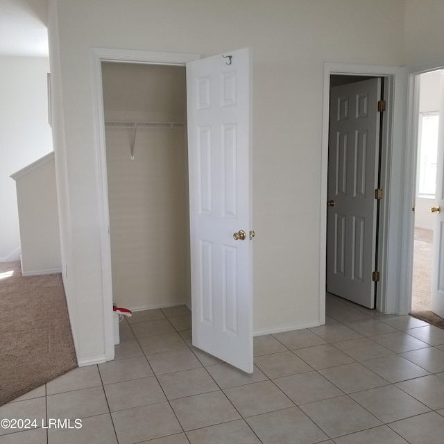 unfurnished bedroom featuring light tile patterned floors and a closet