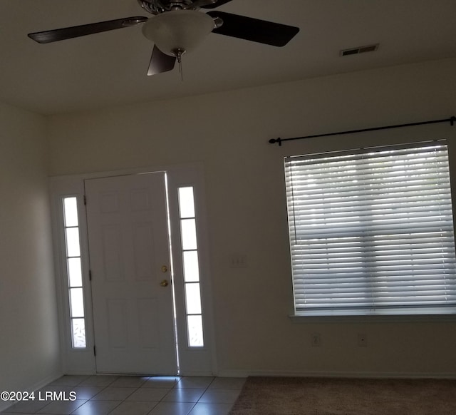 foyer entrance with light tile patterned flooring and a wealth of natural light