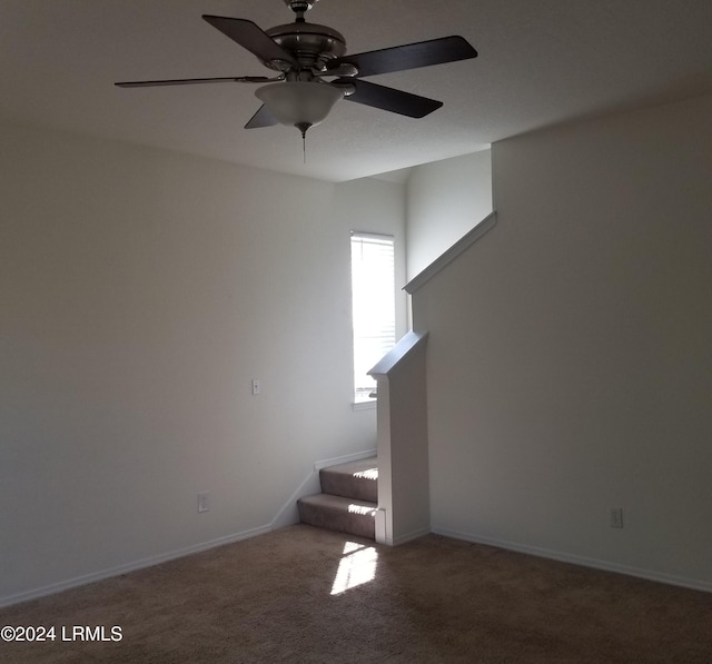 stairway with ceiling fan and carpet floors