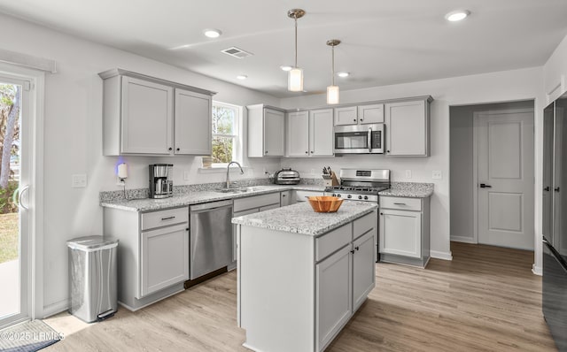 128 Teal Bluff Blvd, Seabrook, SC 29940 - kitchen with stainless steel appliances, gray cabinets, a center island, light wood-type flooring, and light stone countertops
