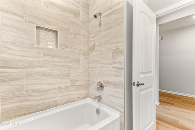 bathroom with wood-type flooring and tiled shower / bath