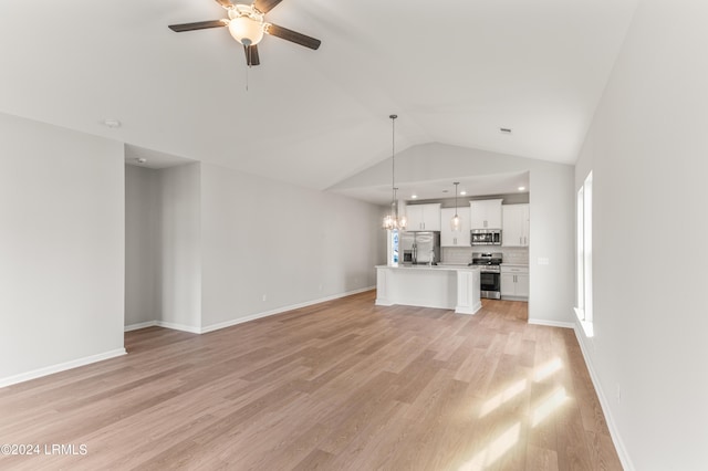 unfurnished living room featuring vaulted ceiling, ceiling fan with notable chandelier, and light wood-type flooring