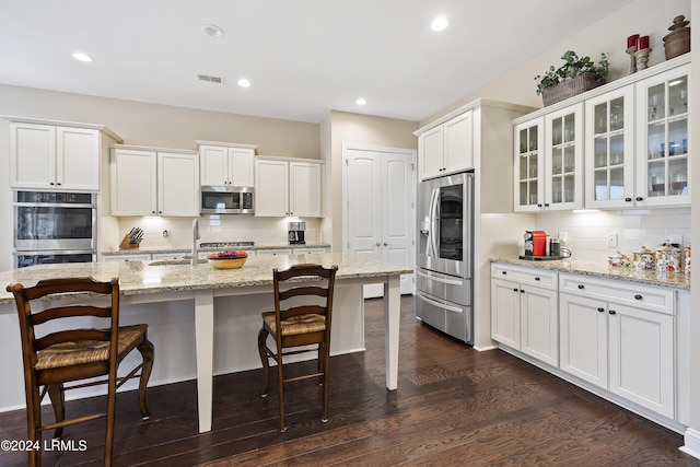 kitchen featuring light stone counters, tasteful backsplash, stainless steel appliances, and white cabinets