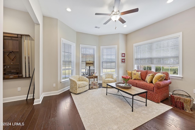 living room featuring dark wood-type flooring, ceiling fan, and a healthy amount of sunlight