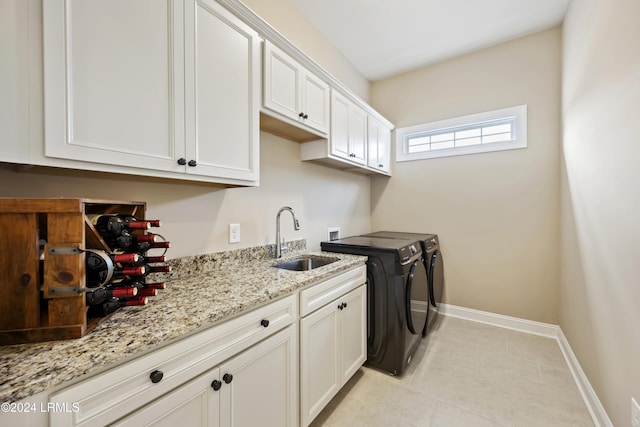 washroom featuring sink, light tile patterned floors, cabinets, and independent washer and dryer