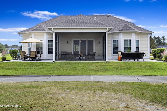 back of property with a patio, a sunroom, and a lawn