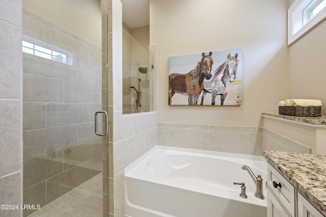 bathroom with vanity, a wealth of natural light, and separate shower and tub