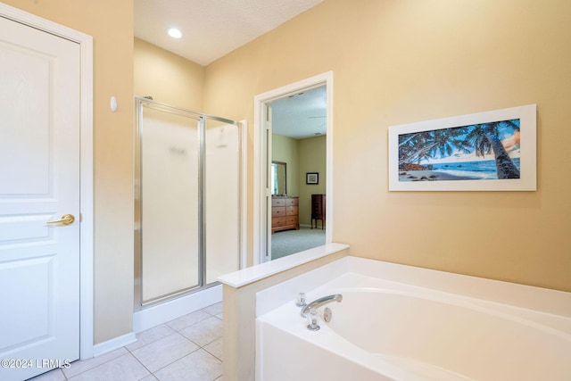 bathroom featuring tile patterned floors, shower with separate bathtub, and a textured ceiling