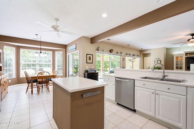 kitchen with sink, decorative light fixtures, a textured ceiling, stainless steel dishwasher, and white cabinets