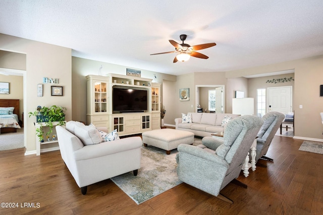 living room featuring ceiling fan, dark hardwood / wood-style flooring, and a textured ceiling