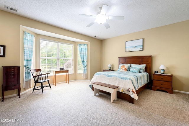 carpeted bedroom with a textured ceiling and ceiling fan