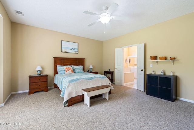 carpeted bedroom featuring ceiling fan, ensuite bathroom, and a textured ceiling