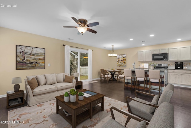 living room featuring ceiling fan and light hardwood / wood-style flooring