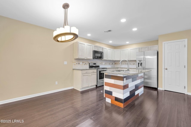 kitchen featuring white cabinetry, sink, backsplash, hanging light fixtures, and stainless steel appliances