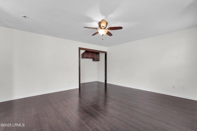 spare room featuring ceiling fan and dark hardwood / wood-style flooring