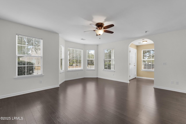 spare room with ceiling fan, plenty of natural light, and dark hardwood / wood-style flooring