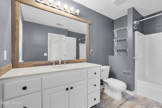 full bathroom with shower / tub combination, vanity, hardwood / wood-style floors, and toilet