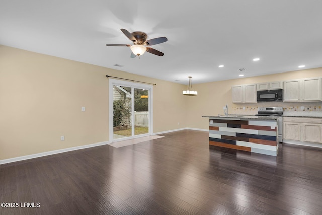 unfurnished living room featuring sink, dark hardwood / wood-style floors, and ceiling fan with notable chandelier