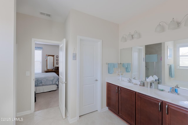 bathroom with a healthy amount of sunlight, independent shower and bath, tile patterned flooring, and vanity