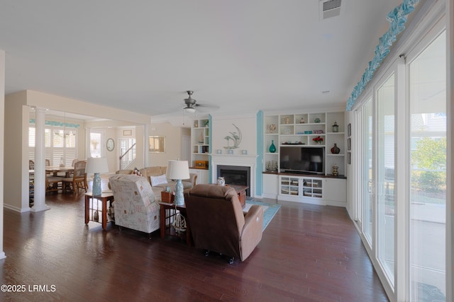 living room featuring ceiling fan, plenty of natural light, and dark hardwood / wood-style flooring