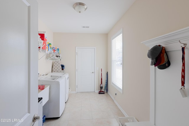 laundry room with separate washer and dryer and light tile patterned flooring